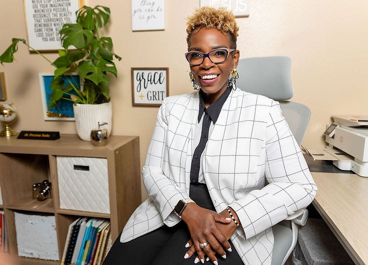 Dr. Precious Parks — white blazer, office setting