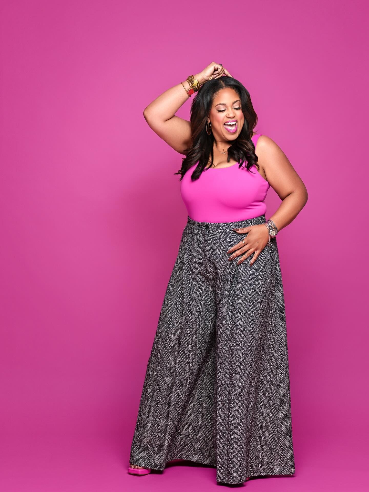 Kyra 50th birthday — pink top, wide-leg pants, standing