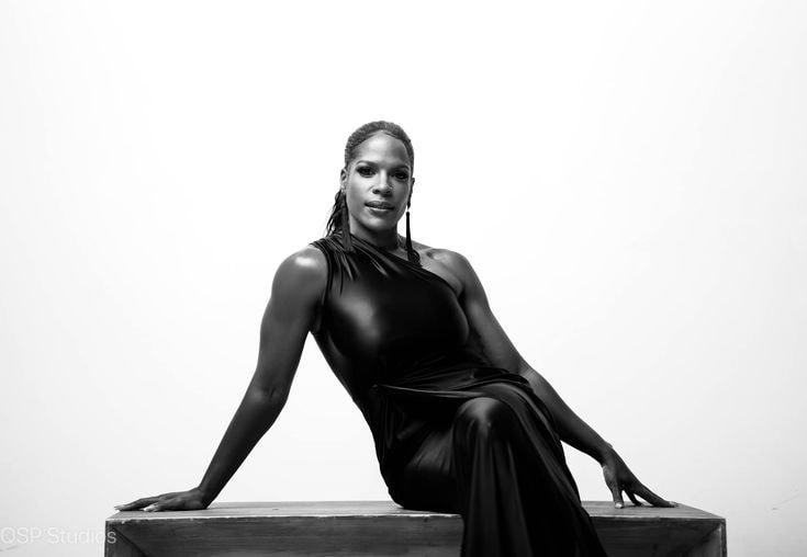 Regina — black dress, B&W seated on platform
