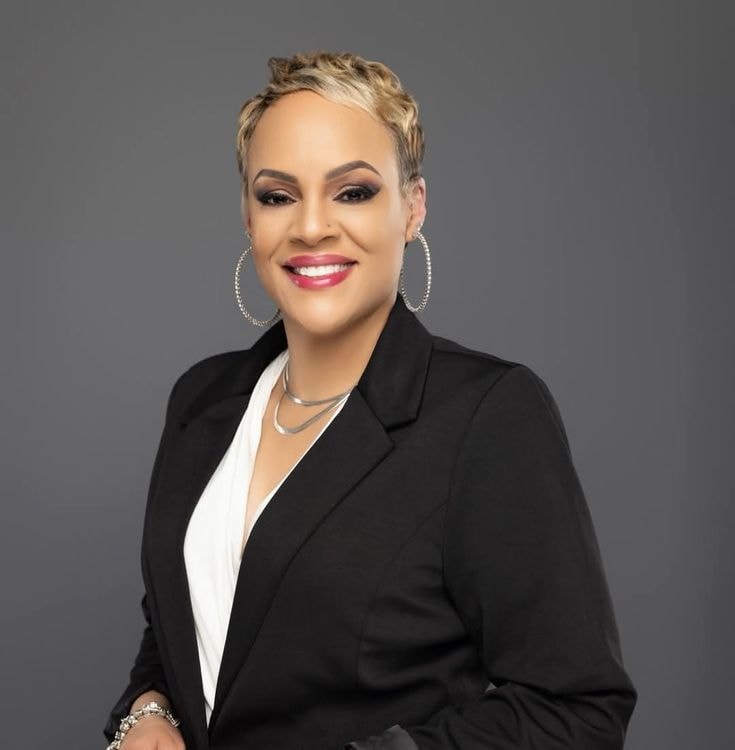 Troi — black blazer, white blouse, silver chain, studio portrait