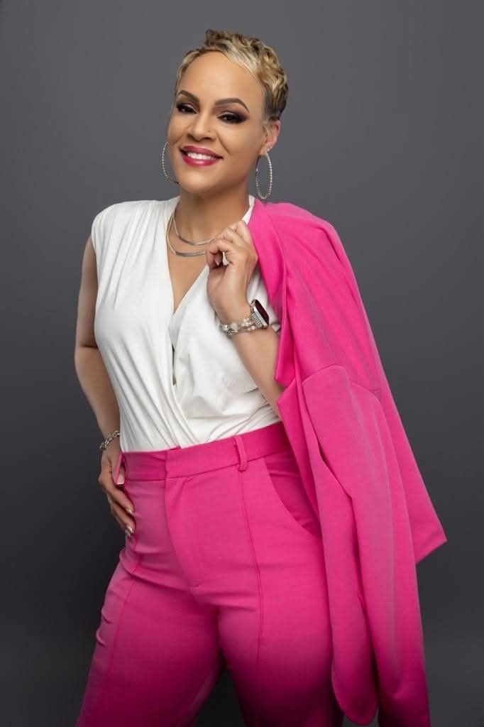 Troi — hot pink suit, white top, studio portrait